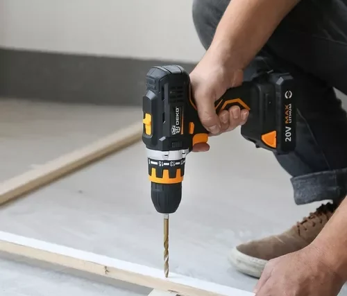 foto mostrando uma mão utilizando uma parafusadeira